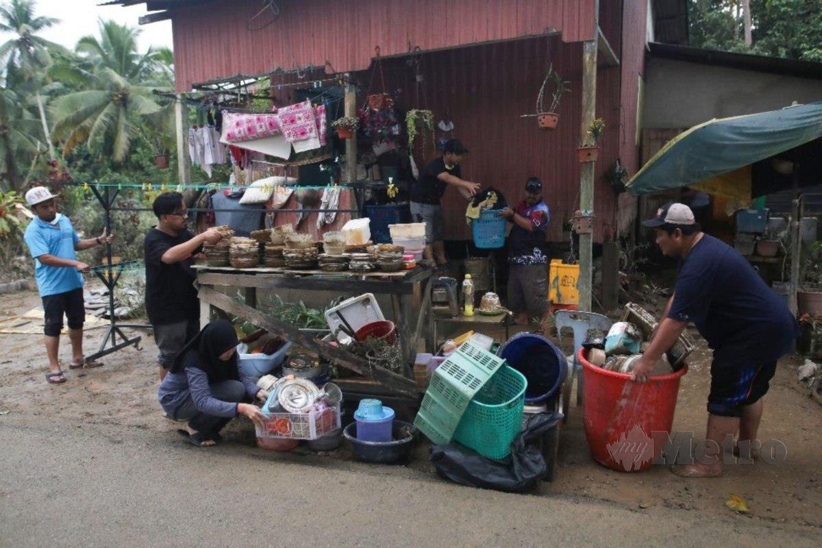 SUKARELAWAN membersihkan rumah suami isteri OKU yang ditenggelami banjir lebih satu meter di Kampung Bukit Mentok. FOTO ZAID SALIM