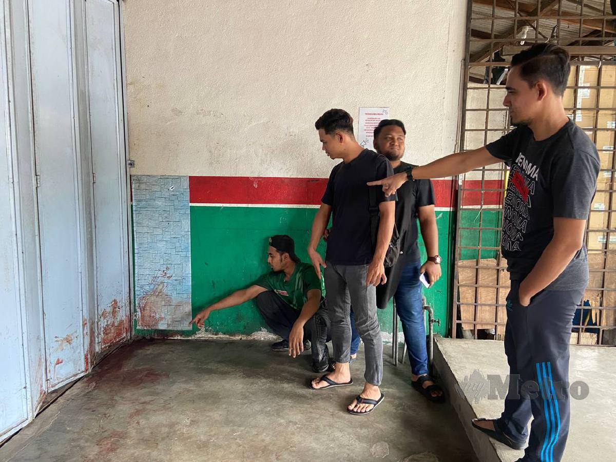ZAHID (kanan) menunjukkan kesan darah mangsa yang terbabit dalam pergaduhan di sebuah kedai di Kampung Cabang Sungai Hala. FOTO Hazira Ahmad Zaidi