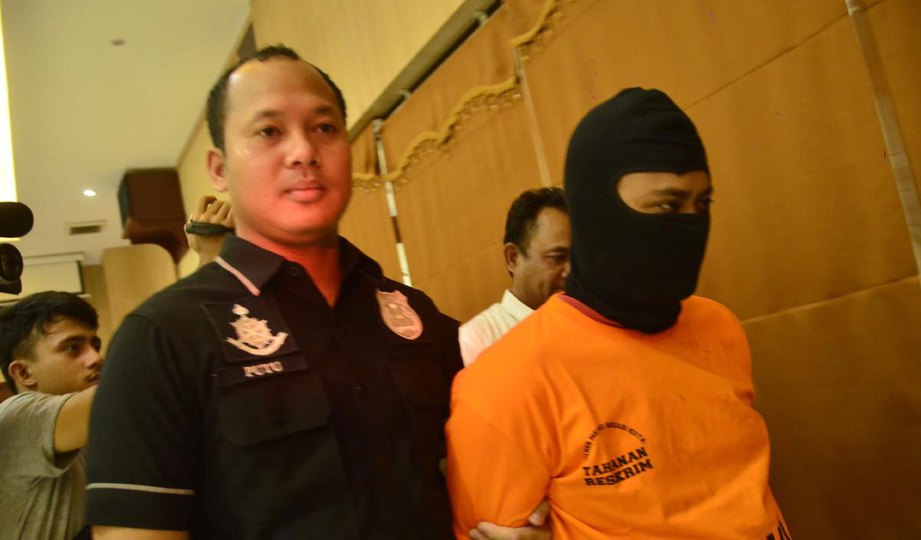 SAADI Muksin (kanan) diiringi anggota polis ketika dibawa ke ibu pejabat polis Bekasi di Jakarta kelmarin. FOTO Liputan6.com