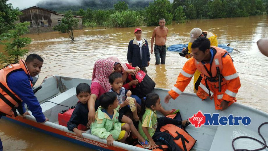Anggota APM memindahkan mangsa banjir di sekitar Besut. FOTO ihsan APM