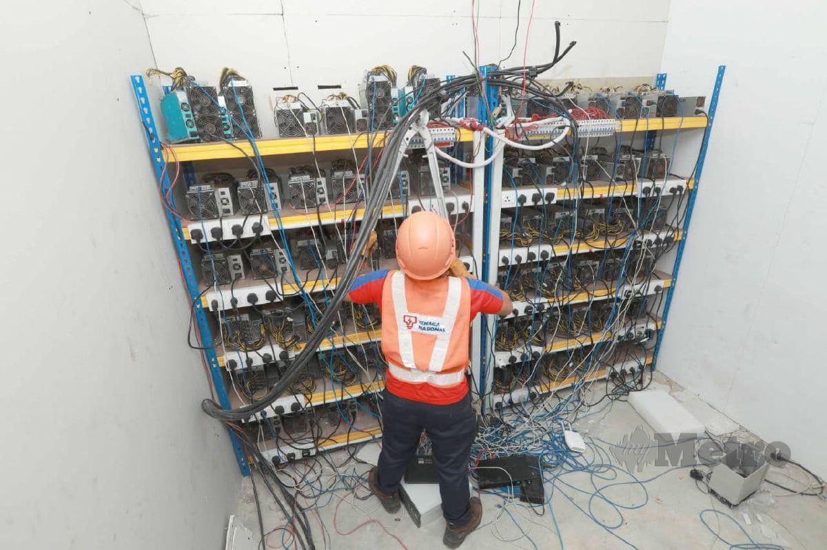 KAKITANGAN TNB memotong kabel elektrik sebuah premis perlombongan bitcoin di Kuantan. FOTO arkib NSTP