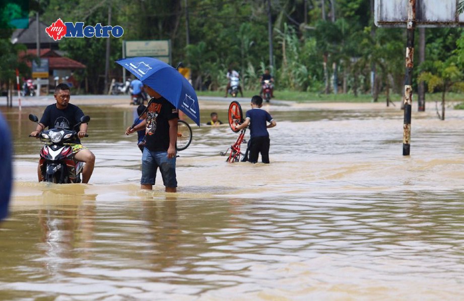 Orang ramai meredah banjir di Kampung Matang, Hulu Telemong. FOTO Rozainah Zakaria