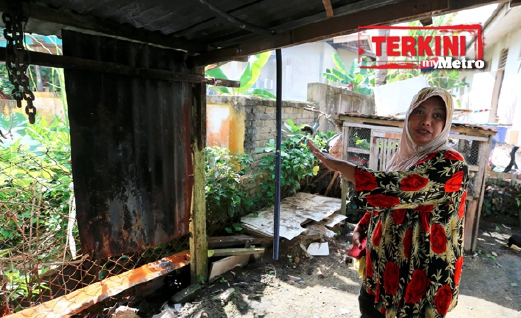  Rafeah menunjukkan lokasi rak pinggan mangkuk di belakang rumah yang terbakar tiba-tiba. - Foto ROZAINAH ZAKARIA