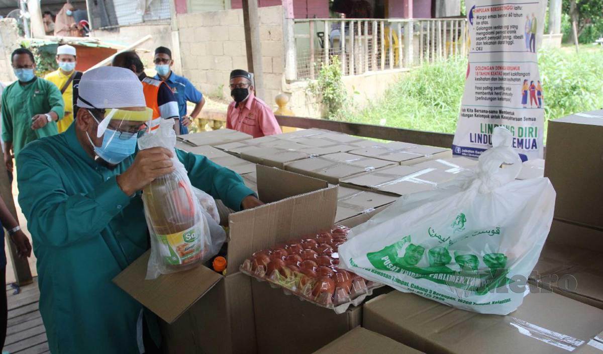 CHE Abdullah memeriksa bekalan makanan untuk disumbangkan kepada 613 keluarga di lapan kampung di delta Sungai Kelantan termasuk empat kampung yang terbabit dengan PKPD Mukim Sungai Pinang ketika ditemui di Jeti Kok Majid. FOTO Nik Abdullah Nik Omar 