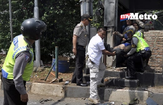 epa05101009 Indonesian police officers evacuate an injured policeman after a bomb blast at a police station in front of a shopping mall in Jakarta, Indonesia, 14 January 2016. Explosions near a shopping centre in the Indonesian capital Jakarta killed at least three people on Thursday, television reports and witnesses said. Police exchanged fire with suspected attackers after the blasts at a traffic police post in front of the Sarinah shopping centre and a nearby Starbucks coffee shop, media reported.  EPA/ALFIAN