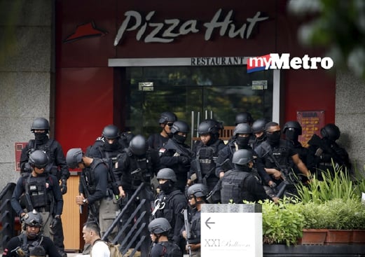 Anggota pasukan anti pengganas polis Indonesia berkumpula di luar sebuah restoran dekat tempat kejadian serangan biom. - Foto REUTERS
