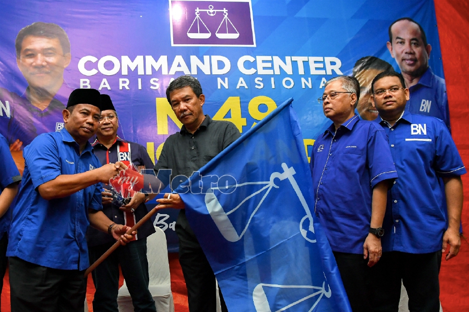 MOHAMAD menyerahkan bendera BN kepada Ketua UMNO Bahagian Kota Raja Datuk Ir Kamaruzzaman Johari (kiri). FOTO BERNAMA 