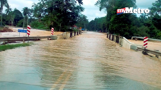 Keadaan jalan Tampin - Gemas yang ditenggelami air sejak semalam. - Foto AMRAN YAHYA