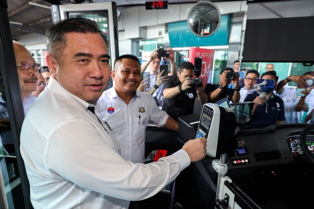 Anthony Loke (kiri) menyempurnakan gimik perasmian Bas Elektrik pada Pelancaran Pas Tanpa Had Mybas50 dan Bas Elektrik bagi Program Mybas Johor Bahru di Terminal Bas Larkin Sentral hari ini. FOTO BERNAMA