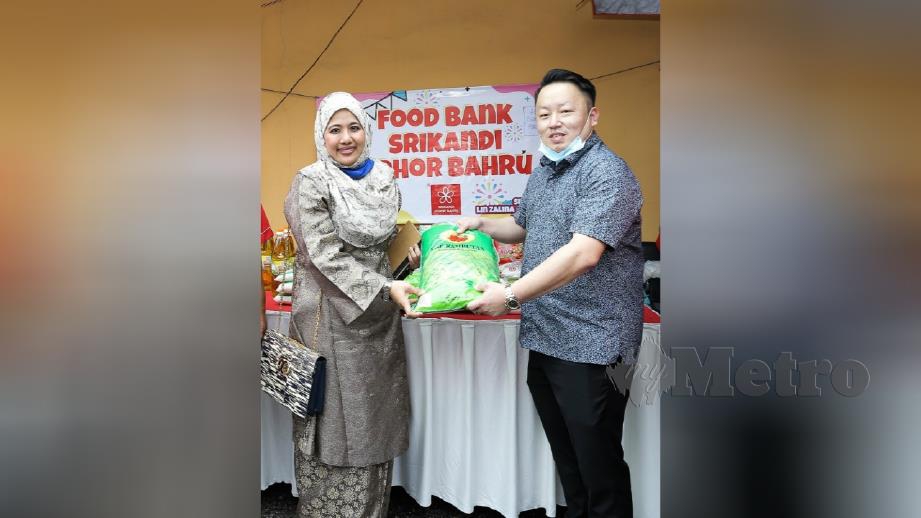 Pengerusi PKJP, Datuk Tan Lek Khang melakukan penyerahan simbolik beras kepada Ketua Srikandi Johor Bahru, Azlinda Abdul Latif bagi program Food Bank pertubuhan itu. FOTO ZAIN AHMED