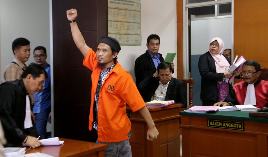 AGUS Supriadi mengangkat tangan  selepas dihukum penjara enam tahun oleh sebuah mahkamah di Jakarta semalam. FOTO EPA