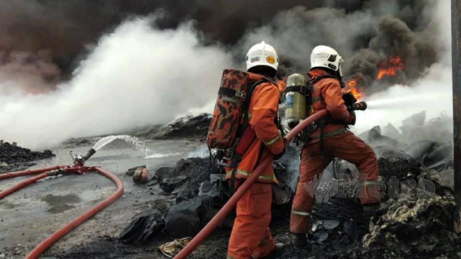 ANGGOTA bomba berusaha memadamkan kebakaran di tapak simpanan komponen kenderaan terpakai di Bandar Armada Putra. FOTO Ihsan Bomba.