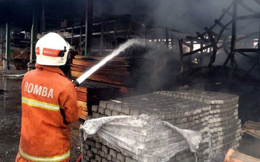 ANGGOTA bomba memadamkan kebakaran sebuah kedai perkakas pembinaan di  Jalan Kampung Baru Subang, semalam.