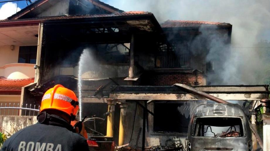 Anggota bomba memadam kebakaran sebuah rumah dan tiga kenderaan di Miri. FOTO JBPM