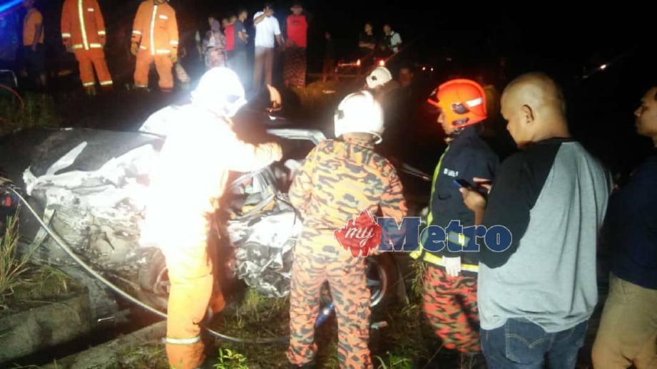 ANGGOTA bomba berusaha mengeluarkan mayat mangsa yang tersepit dalam kereta Proton Iswara yang terhumban ke dalam cerun di lokasi kemalangan di simpang Felda Belara, Kuala Nerus, malam tadi. FOTO ihsan bomba. 