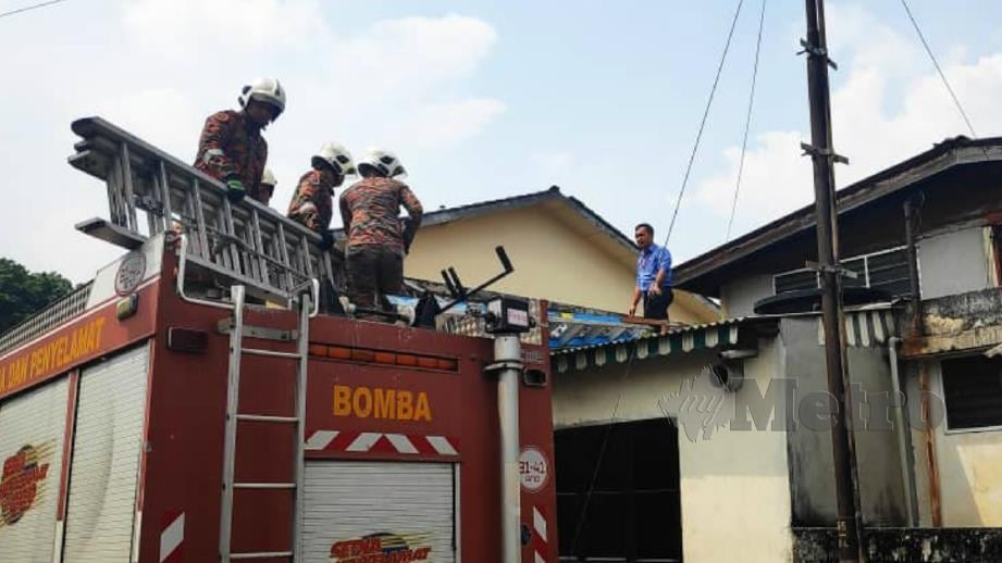Anggota bomba membawa turun warga emas yang pitam di bumbung rumahnya. FOTO Ihsan JBPM 