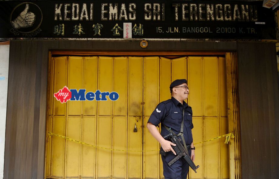 Anggota polis mengawal tempat dalam kejadian pecah masuk kedai emas di Jalan Banggol. FOTO Mohd Syafiq Ridzuan Ambak 
