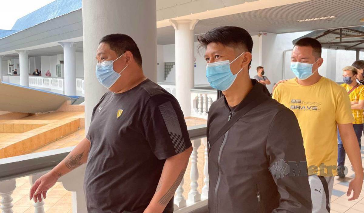 LEANG Tin Sheng (kiri) dan Tey Boon Sin dibawa keluar dari Mahkamah Sesyen Ayer Keroh selepas dijatuhi hukuman denda. FOTO Nuraliawati Sabri