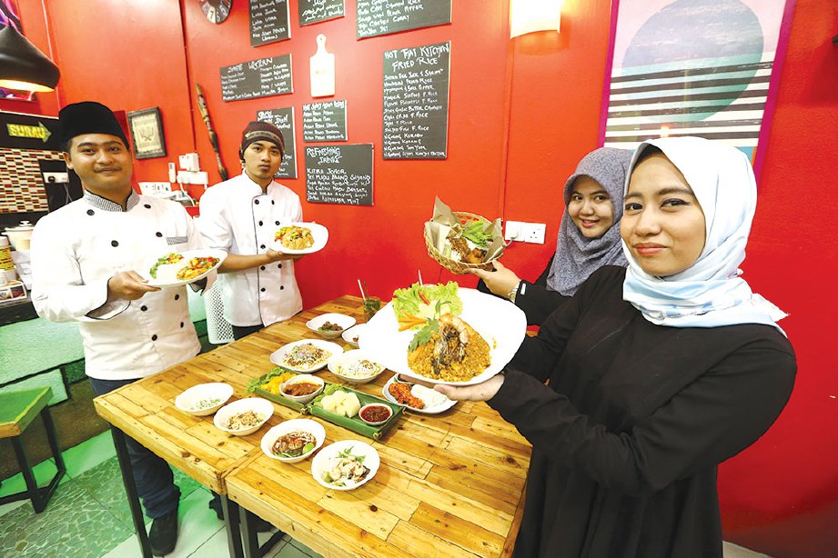 FASIHAH (kanan) bersama pekerja di restorannya.