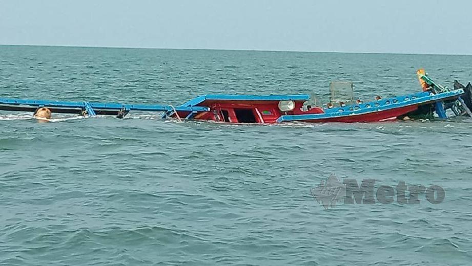 KEADAAN bot yang terbalik dalam kejadian perairan Kemasin kini diletakan di Muara Kemasin bagi memudahkan percarian mangsa yang hilang. FOTO NIK ABDULLAH NIK OMAR
