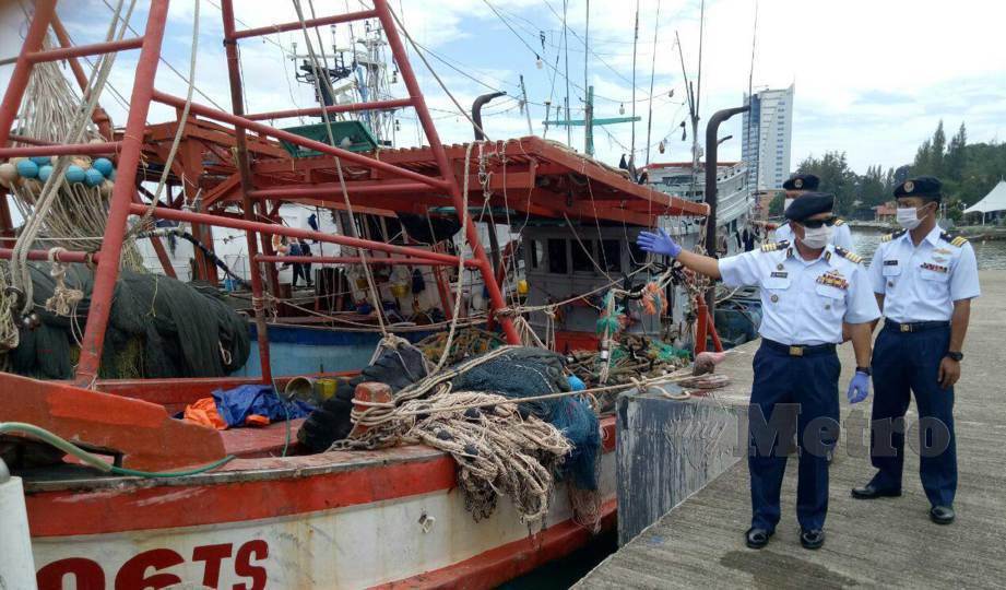 MUHAMMAD Suffi bersama pegawai meninjau dua kapal nelayan Vietnam yang ditahan kerana menceroboh perairan negeri di Pengkalan Ibu Pejabat Maritim, Kuala Terengganu. FOTO Baharom Bakar