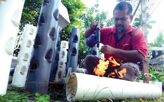 NIK Ismail menunjukkan cara membuat lubang pada paip PVC untuk dijadikan pasu.