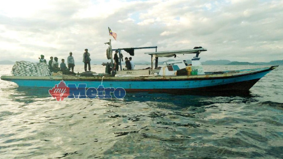 BOT nelayan tempatan bersama sembilan kru warga Filipina yang ditahan di perairan Pulau Mabul, Semporna, semalam. FOTO Maritim Malaysia