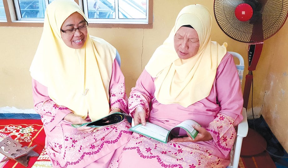 KAMSIAH (kanan) membaca al-Quran sambil didengari Fadilah.