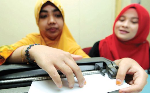 NUR Hayati dibantu Nik Fatin Asyikin menaip cetakan al-Quran Braille untuk OKU cacat penglihatan.