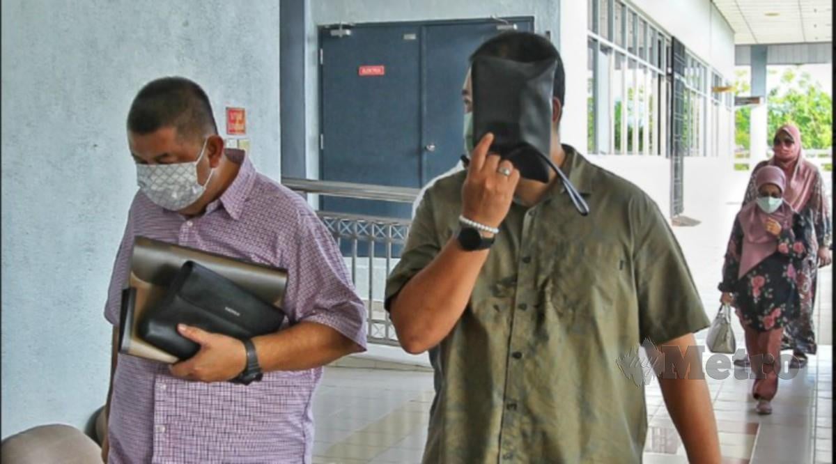 MOHD Zamry (baju hijau) dan Anuar (baju merah jambu) didakwa di Mahkamah Sesyen Seremban atas tuduhan menerima suapan berjumlah RM350,000, hari ini. FOTO Azrul Edham