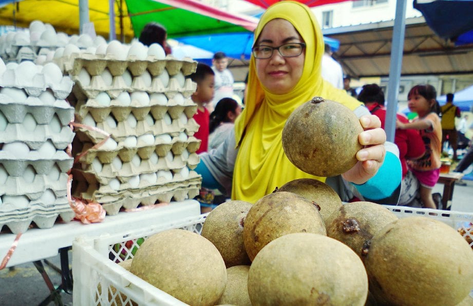 NORLINAH menjual telur itik masin serta buah Bambangan di Tamu Jalan Gaya, Kota Kinabalu.