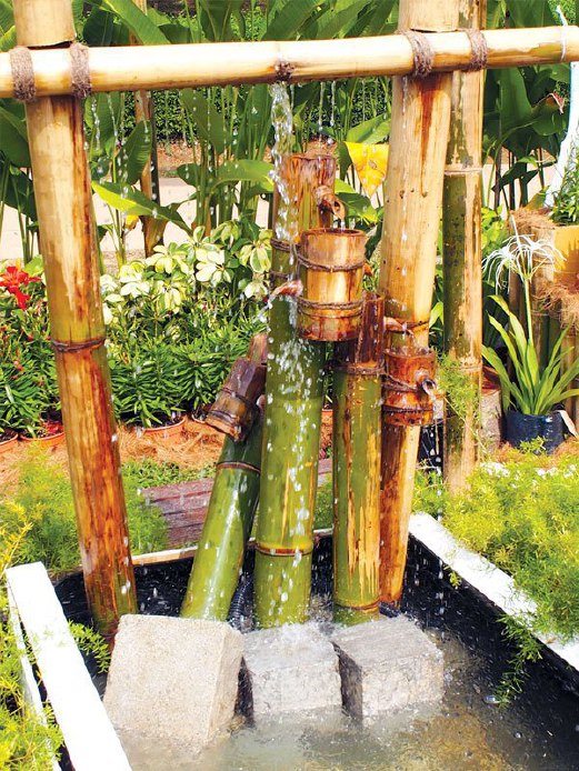 PENYEJUK taman dengan air berpancuran daripada susun atur buluh secara kreatif.