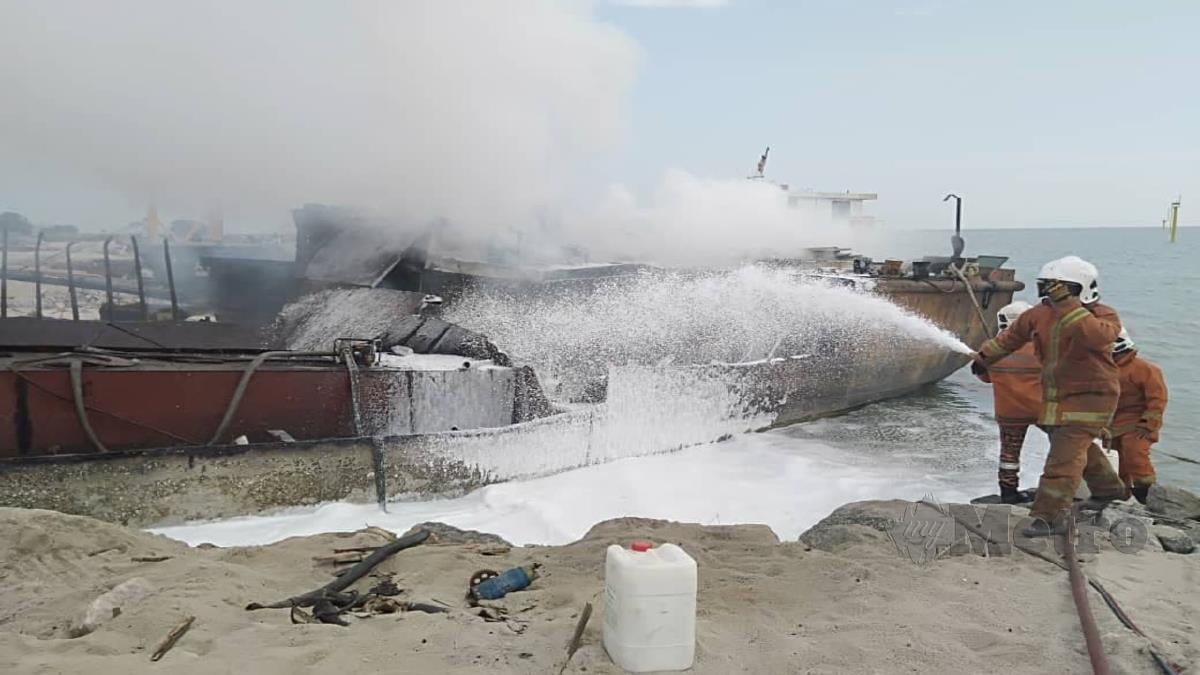 ANGGOTA bomba memadam kebakaran sebuah kapal korek pasir. FOTO Nuraliawati Sabri