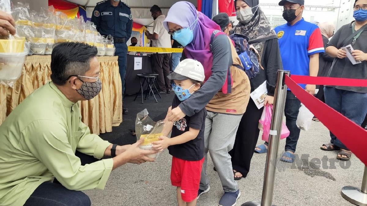 JALALUDDIN (kiri)  mengagihkan bubur lambuk kepada orang ramai yang hadir di bazar Ramadan Putrajaya Presint 3 semalam. FOTO Samadi Ahmad.