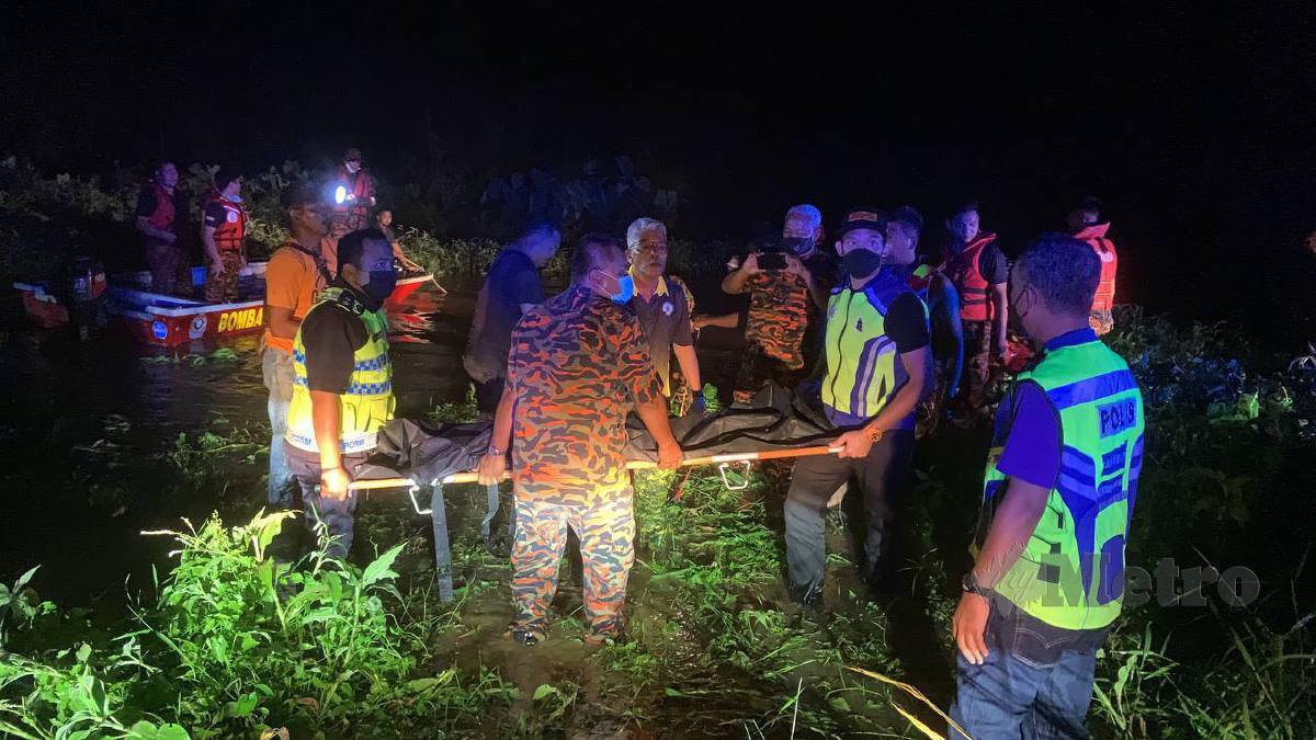 PASUKAN penyelamat mengangkat mayat kanak-kanak lelaki yang ditemukan lemas selepas terperangkap dalam kereta ibunya yang terbabas ke dalam tali air, malam ini. FOTO NOOR HIDAYAH TANZIZI.