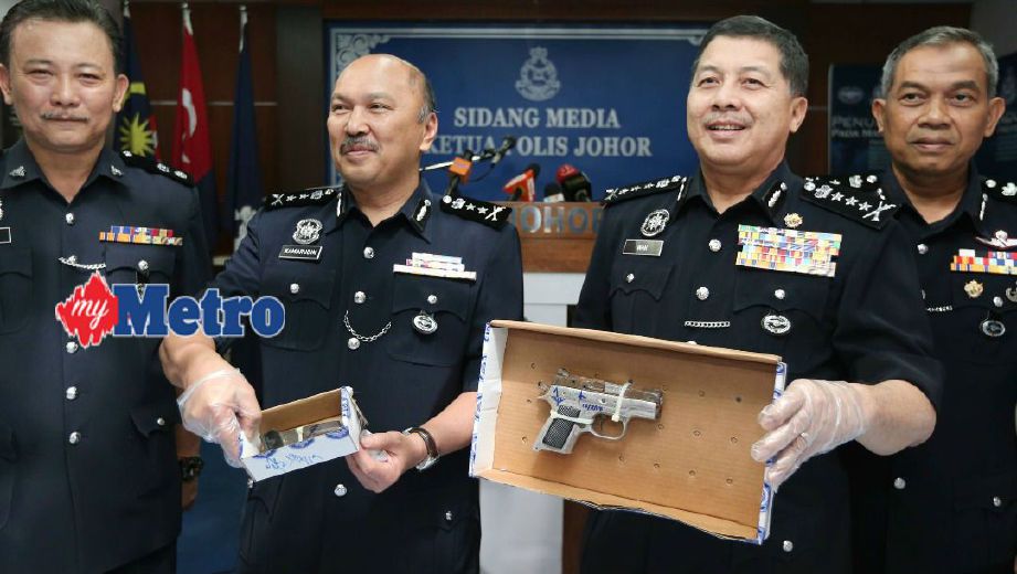 Wan Ahmad Najmuddin (dua dari kanan) menunjukkan pistol yang dirampas pada sidang media di IPK Johor Bahru. FOTO Mohd Azren Jamaludin