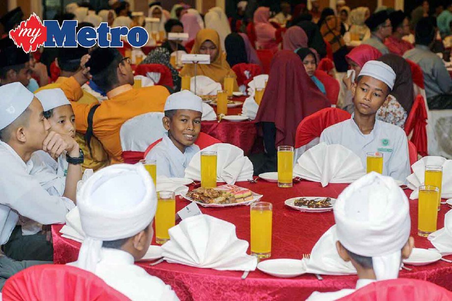 SEBAHAGIAN daripada 103 pelajar miskin menjamu selera pada Majlis Iftar Amal Ihtiman Ramadan di Hotel Perdana. -Foto NIK ABDULLAH NIK OMAR