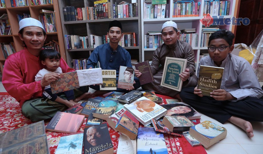 MOHD Saiful Nizam bersama adik-beradiknya menunjukkan koleksi buku peninggalan Mokhtar. FOTO Ghazali Kori.