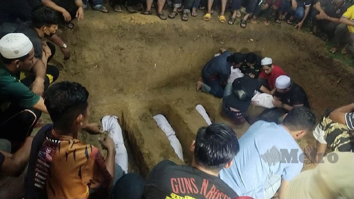 Jenazah lima beranak disemadikan dalam satu liang di Perkuburan Islam Labu Kubong, Kampung Labu Kubong, di sini malam ini. FOTO MUHAMMAD ZULSYAMINI SUFIAN SURI
