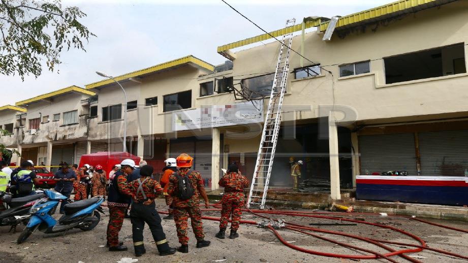 ANGGOTA bomba melakukan pemeriksaan di sebuah rumah kedai yang terbakar di Kawasan Perindustrian Jelapang Maju, Jelapang, Ipoh, hari ini. Foto MUHAIZAN YAHYA