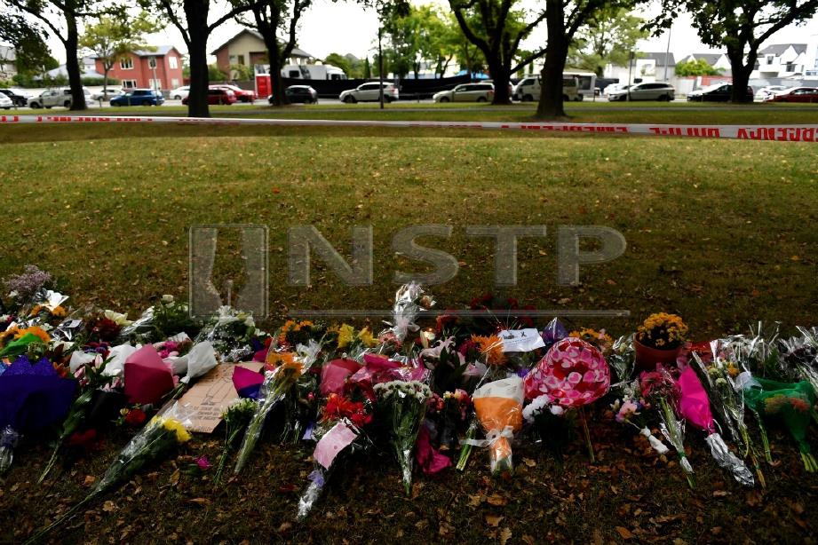 ORANG ramai meletakkan bunga berhampiran lokasi serangan pengganas dekat masjid di Christchurch. FOTO Agensi 