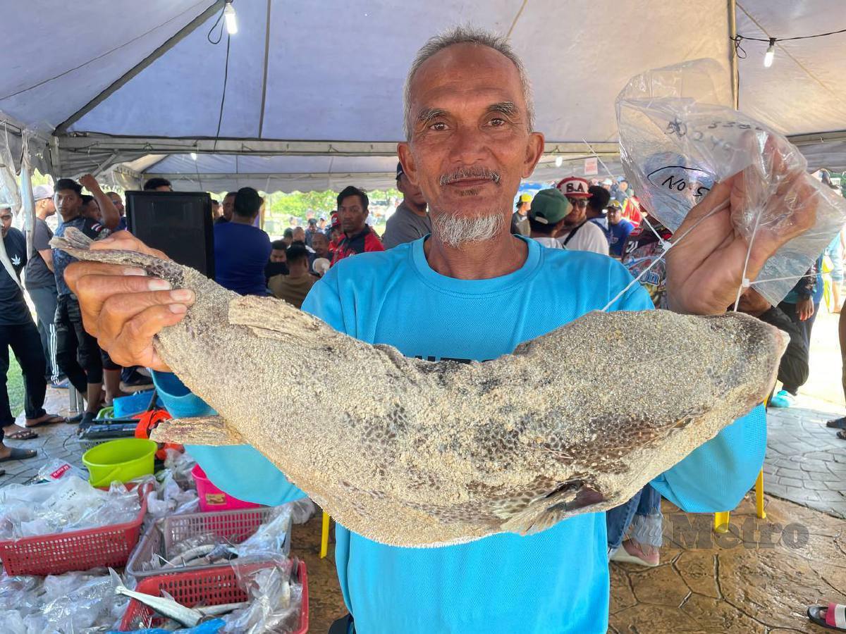 ZAHRI menunjukkan ikan buntal yang dipancingnya seterusnya memenangi hadiah wang tunai RM105,000. FOTO Ahmad Rabiul Zulkifli