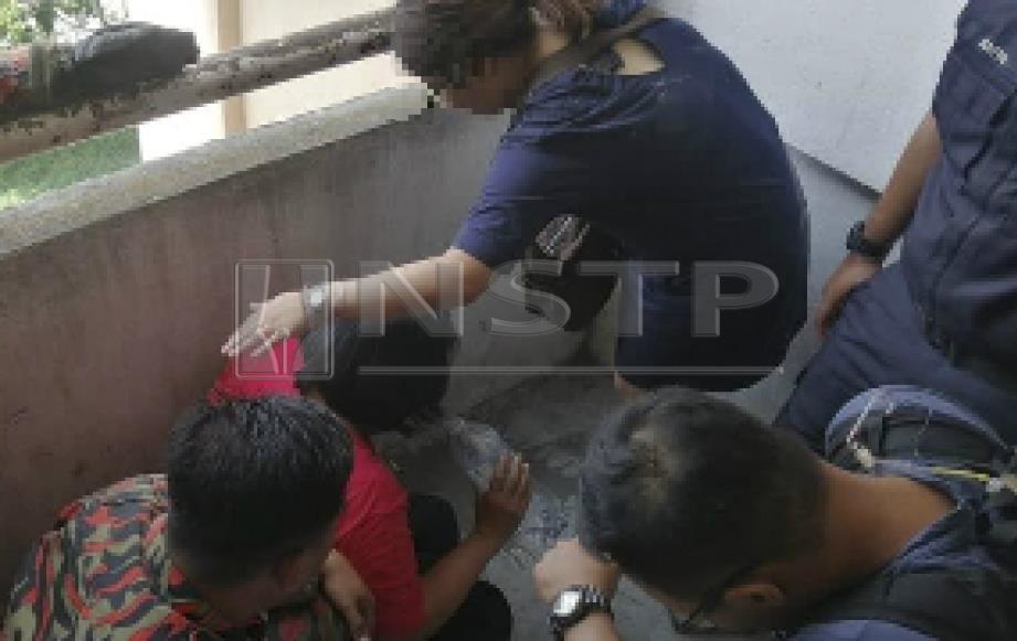 Wanita yang cuba bunuh diri ditenangkan ahli keluarga dan anggota pasukan penyelamat selepas diselamatkan di Taman Permai Indah, Pandamaran Jaya di Klang. FOTO Ihsan JBPM 