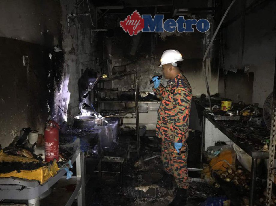 Ketua Pegawai Penyiasat Kebakaran, Timbalan Penguasa Bomba Bahagian Penyiasatan Kebakaran Mohd Sufian Hassan memeriksa dapur restoran Rockstarz Burger yang musnah terbakar.  FOTO RUDY SYAREME SHERIFFUDIN