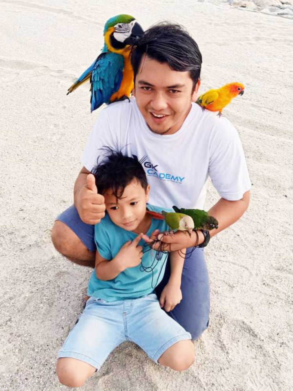 MOHD Faizal bersama anaknya bermain dengan kakaktua peliharaannya.