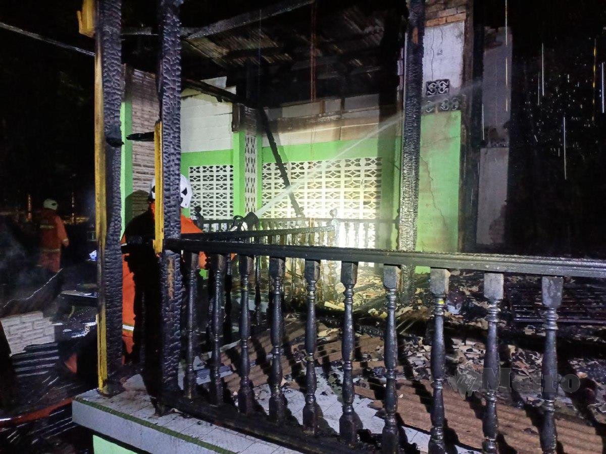 ANGGOTA bomba memadamkan kebakaran sebuah rumah yang mengorbankan seorang wanita warga emas di Kampung Bukit, Wakaf Bharu. FOTO Siti Rohana Idris.