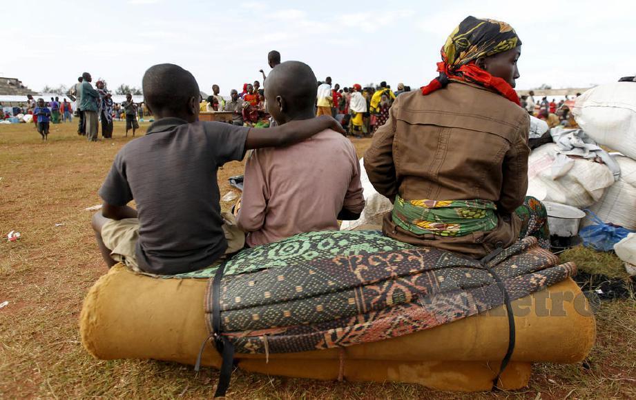 PELARIAN Burundian duduk di atas barang-barang mereka di stadium Lake Tanganyika di Kigoma barat Tanzania.