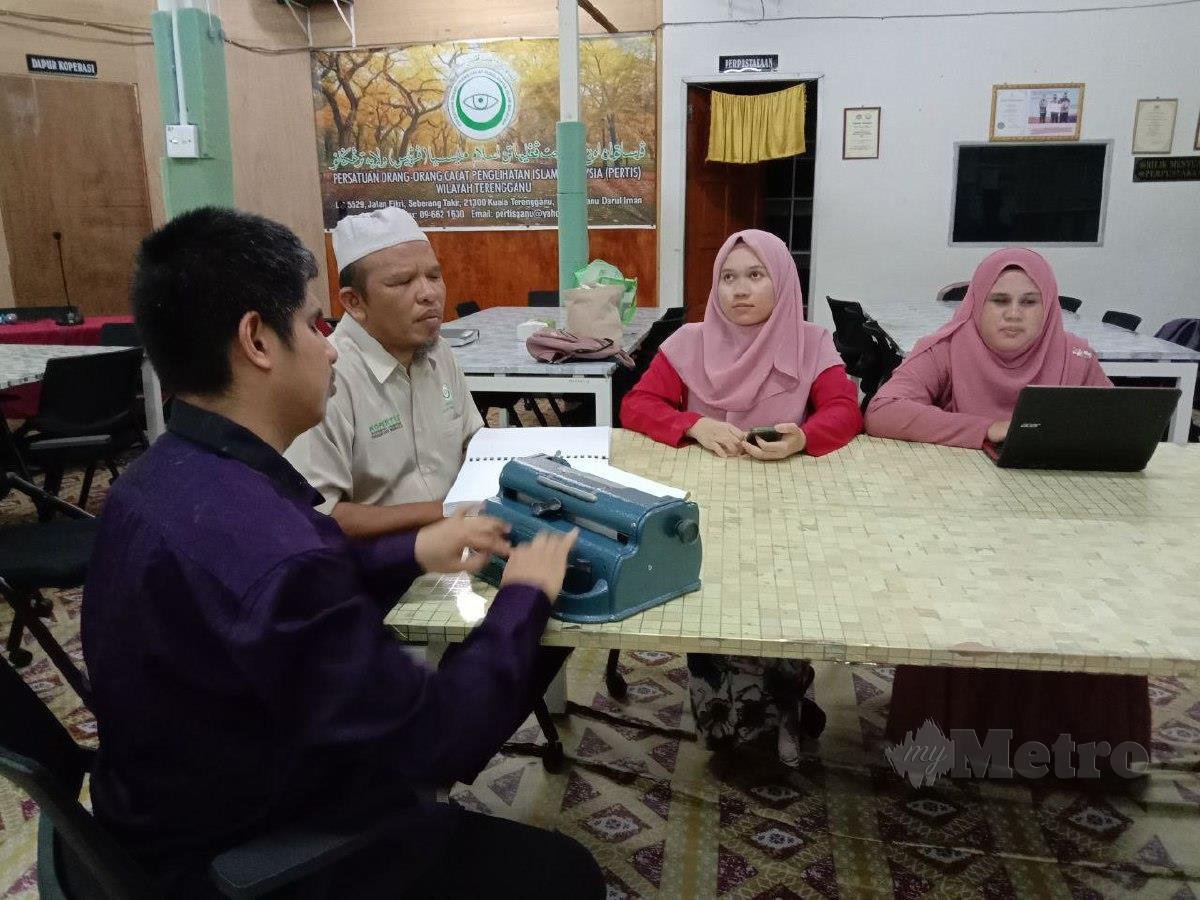 Nurul Najwa sedang mengendalikan komputer riba manakala Nurul Syahida menggunakan telefon bimbit ketika mendengar taklimat di sampaikan Pengerusi Persatuan Orang-Orang Cacat Penglihatan Islam Malaysia (PERTIS) Wilayah Terengganu, Fauzi Mansor, (tengah). FOTO NAZDY HARUN