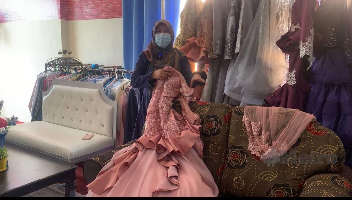 NURASIDAH menunjukkan baju pengantin di butiknya yang boleh disewa dengan bayaran RM110 bersama aksesori. FOTO IZAD THAQIF HASSAN
