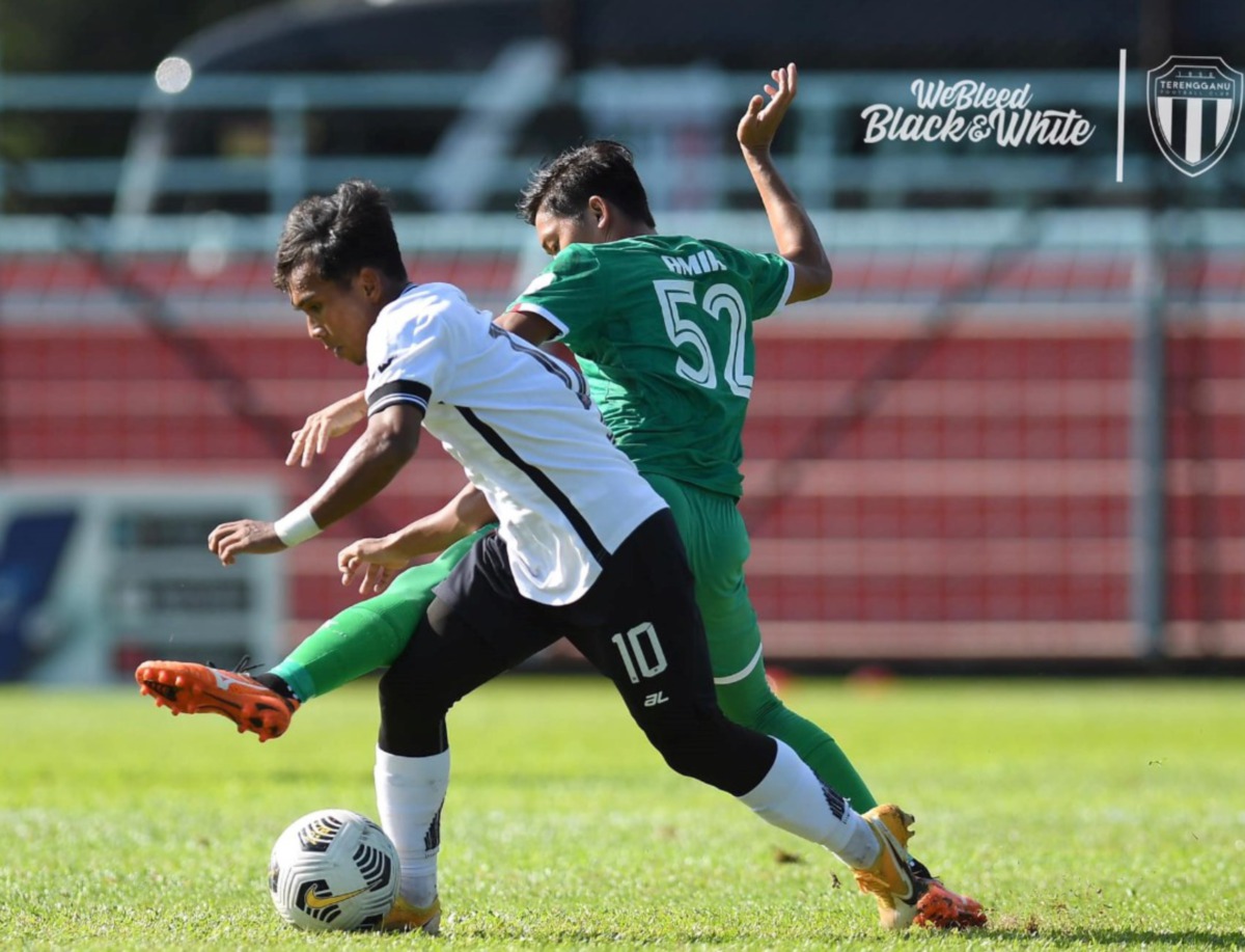 PEMAIN TFC II, Syafik Ismail (kiri) cuba melepasi kawalan pemain Kuching City FC, Amir Amri Salleh pada aksi tertunda Liga Perdana di Stadium Majlis Bandaraya Pasir Gudang, semalam. FOTO Ihsan Terengganu FC II.